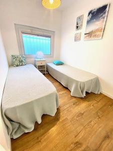 a bedroom with two beds and a window at Maison, jardinet, terrasse, parking privée, climatisation in Saintes-Maries-de-la-Mer