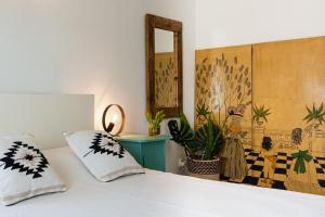 a bedroom with a bed with a mirror and plants at Torre Mirador Azul 2 habitaciones in Tossa de Mar