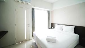 Postel nebo postele na pokoji v ubytování Cozy Stay 2BR at The Square Surabaya Apartment By Travelio
