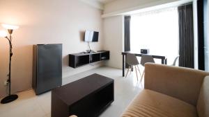 TV a/nebo společenská místnost v ubytování Cozy Stay 2BR at The Square Surabaya Apartment By Travelio