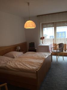 a bedroom with two beds and a table and a window at Gästehaus Schrötter in Lam