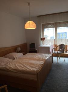 1 Schlafzimmer mit 2 Betten, einem Tisch und einem Fenster in der Unterkunft Gästehaus Schrötter in Lam