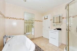 a bathroom with a tub and a shower and a sink at Modern 3 Bed Home - Solihull Centre in Solihull +19 photos