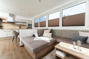 a living room with a couch and some windows at Appartement Schöpf in Längenfeld