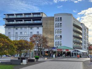 a large white building with a street in front of it at Hotel Aurora Family & SPA in Międzyzdroje