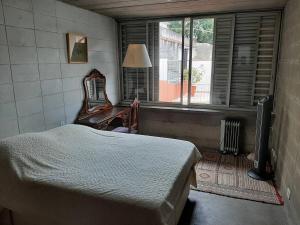a bedroom with a bed and a chair and a window at Kulturhaus in Sao Paulo