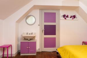 a bathroom with purple doors and a sink at Maison dans le Morbihan in La Chapelle-Caro +13 photos