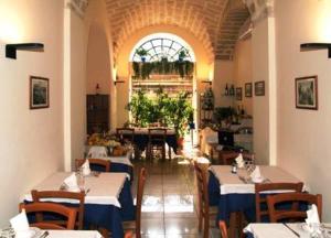 ein Esszimmer mit Tischen und Stühlen und einem Fenster in der Unterkunft Hotel Adria in Bari