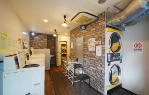a laundry room with a washer and a brick wall at 東京リリアルホテル201 in Tokyo