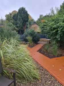 a garden with a red brick path and plants at Gästehaus Wolkenlos in Fehmarn