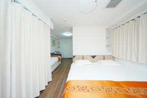 a bedroom with two beds and white curtains at 東京リリアルホテル201 in Tokyo
