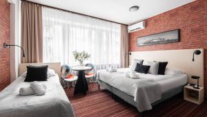 a hotel room with two beds and a brick wall at Hotel Delta in Krakow +36 photos