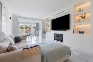 un soggiorno con divano e TV a schermo piatto di Luxurious And Modern Family Home a Málaga