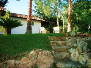 a yard with a stone wall and a house at Casetta Giuliana in Noto Marina