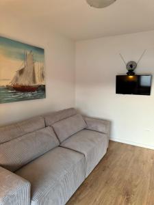 ein Wohnzimmer mit einem Sofa und einem Schiffsbild in der Unterkunft Apartman Vitanov in Vinišće
