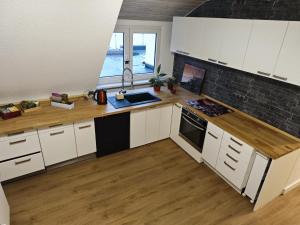 a kitchen with white cabinets and a wooden counter top at Gemütliche Ferienwohnung in Essen +18 photos