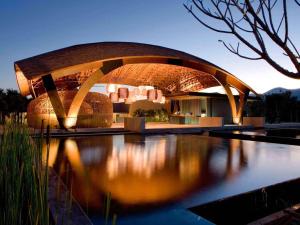 杭东Veranda High Resort Chiang Mai - MGallery Collection的倒映在水中的圆形建筑