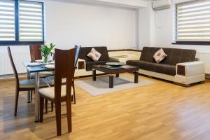 a living room with a couch and a table at Central Apartments - Green in Bacău