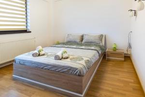 a bedroom with a bed with two pillows on it at Central Apartments - Green in Bacău
