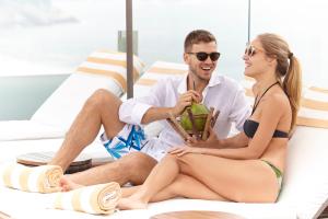 a man and a woman sitting on a beach chair at PortoBay Rio de Janeiro in Rio de Janeiro