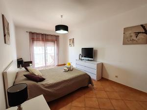 een slaapkamer met een bed met een teddybeer erop bij 4D Terrace A - Casas & Papeis in Armação de Pêra