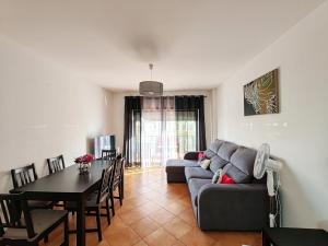 een woonkamer met een bank en een tafel bij 4D Terrace A - Casas & Papeis in Armação de Pêra
