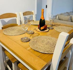 a wooden table with glasses and a bottle of wine at The Lookout in Carbis Bay