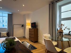 a living room with a table and a dining room at Beautifully Central & Superior Apartment Book Now in Kent