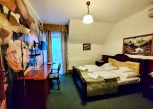 a bedroom with a bed and a desk in it at HOTEL RESTAURACJA WESOŁA in Lisia Góra