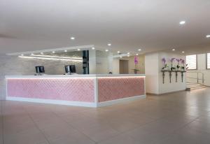a lobby with a pink and white reception desk at Olé Tropical Tenerife Adults Only in Playa de las Americas
