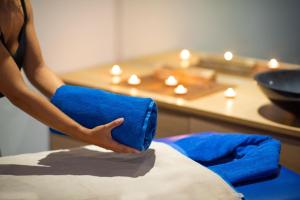 a woman holding a blue pillow on top of a bed at Olé Tropical Tenerife Adults Only in Playa de las Americas