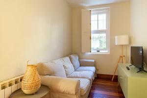 a living room with a couch and a tv at Casabonita Santander in Santander +22 photos