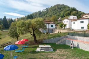 a group of umbrellas and chairs with a pool at Chalet La Greta Vista Superiore in Firenzuola