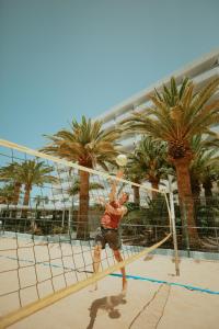 a man is playing volleyball on a volleyball net at Olé Tropical Tenerife Adults Only in Playa de las Americas