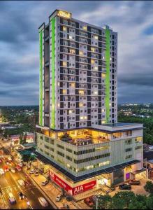 Un edificio alto con luces encendidas en una ciudad. en A cozy home feel with a city view - The Capitol at Sitari, en Bacolod