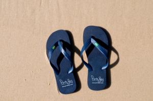 a pair of blue flip flops on the sand at PortoBay Rio de Janeiro in Rio de Janeiro