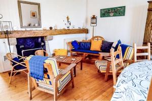 a living room with a couch and a table and chairs at La Maison de la Plage - vue mer, 5' du port, 6 personnes in Île-Tudy