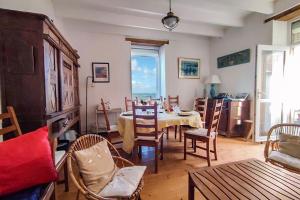 a living room with a dining room table and chairs at La Maison de la Plage - vue mer, 5' du port, 6 personnes in Île-Tudy