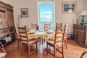 a dining room with a table and chairs at La Maison de la Plage - vue mer, 5' du port, 6 personnes in Île-Tudy