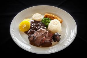 a white plate of food with meat and other foods at PortoBay Rio de Janeiro in Rio de Janeiro