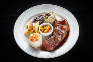a plate of food with meat rice and fries at PortoBay Rio de Janeiro in Rio de Janeiro