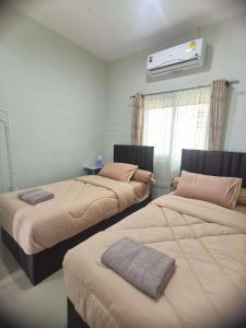 a bedroom with two beds and a air conditioner at Yada House twin bed in Nai Yang Beach