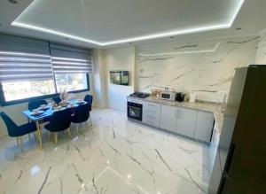 a kitchen with a table and blue chairs in a room at Appartement Centre ville Tanger in Tangier