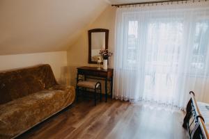 a living room with a couch and a mirror at Apartament Róża in Solec-Zdrój