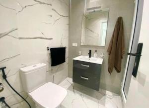 a bathroom with a toilet and a sink and a mirror at Appartement Centre ville Tanger in Tangier +10 photos