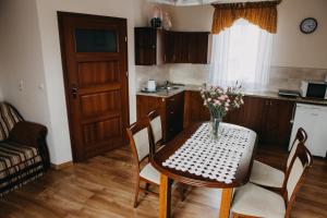 a kitchen with a table with a vase of flowers on it at Apartament Róża in Solec-Zdrój