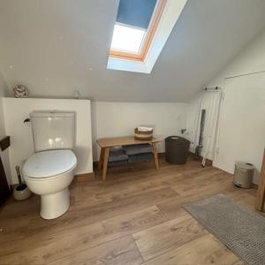 a bathroom with a white toilet and a wooden floor at Appartement 2 personnes in Lestrem +6 photos