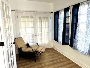 a chair sitting in a room with windows at Downtown Retreat - Cozy First Floor in Columbus