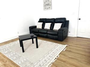 a black leather couch sitting in a living room with a table at Downtown Retreat - Cozy First Floor in Columbus