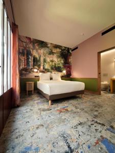 a bedroom with a bed and a painting on the wall at Hôtel Relais Monceau in Paris